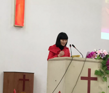 A female pastor preaches in a church. 