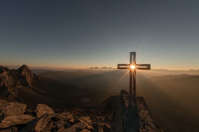 A cross on a hill facing the setting sun.