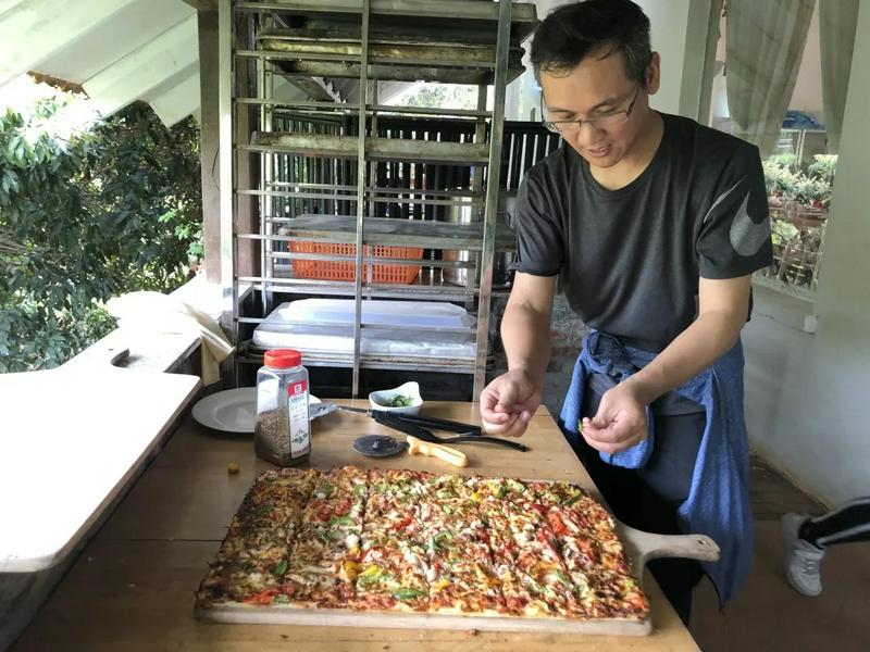 A volunteer from Guangxiao Church in Guangzhou made a big pizza for youths with intellectual disabilities in Huiling Farm on March 28, 2021.