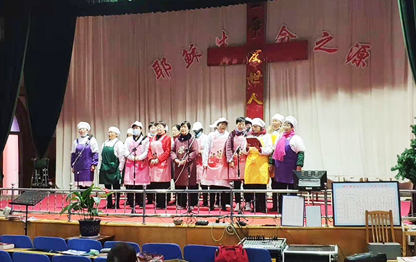 Canteen workers of Linyi County Church, Yuncheng, Shanxi Province, sang hymns on the stage to mark Easter on April 4, 2021.