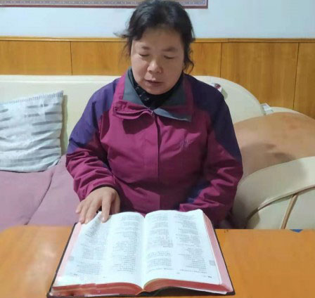 Sister Kang reads the Bible at her home.