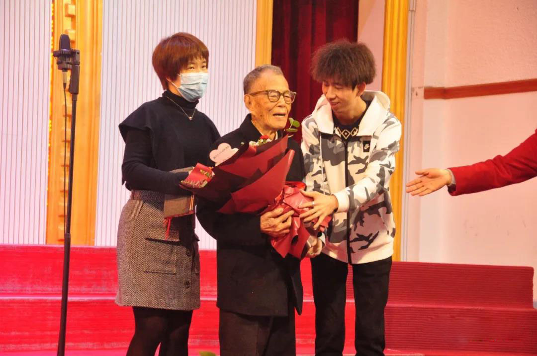 Ju Zengxi, a 100-year-old pastor, received a bouquet of flowers from a young pastor in his testimony service at Gospel Church in Xijin Road, Ganzhou City, Jiangxi Province on April 17, 2021.