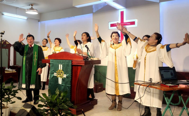 Zhang Zhongye, senior pastor of Beihai Church, Guangxi Province and choir members worshiped God in a webcasting Sunday service in the church on February 7, 2021.