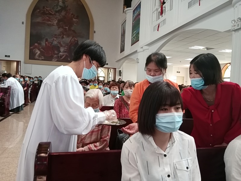 A deacon distributed the bread to congregation in a communion service held in Shilipu Church, Baoji, Shaanxi, on June 6, 2021.
