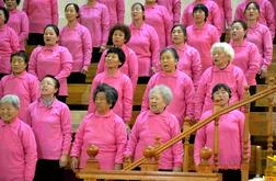 Chinese female believers, dressed in pink blouse, sing hymns.