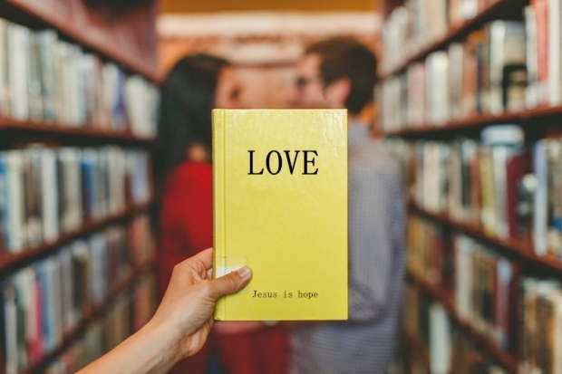 A book named "Love" in front of a couple