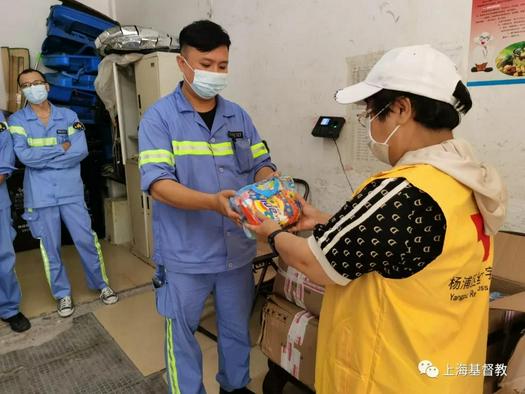 A sanitation worker in Yangpu District of Shanghai received products for heatstroke prevention from a local Christian volunteer in late August.