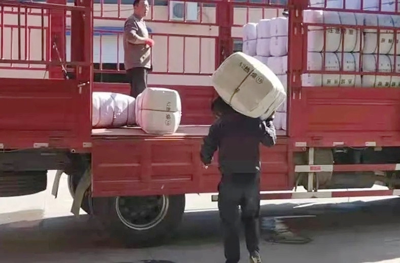 Volunteers of the Amity Foundation loaded quilts which were to be delivered to flood-hit Songgu Township, Jiexiu City, Jinzhong City, on October 11, 2021.