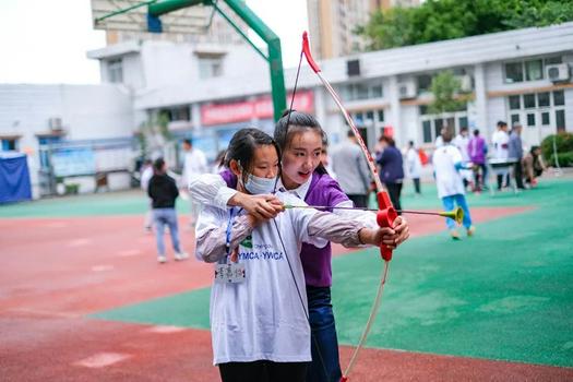 A volunteer of Chengdu YWCA helped a special child compete in archery at Jintang Special Education School on October 10, 2021.