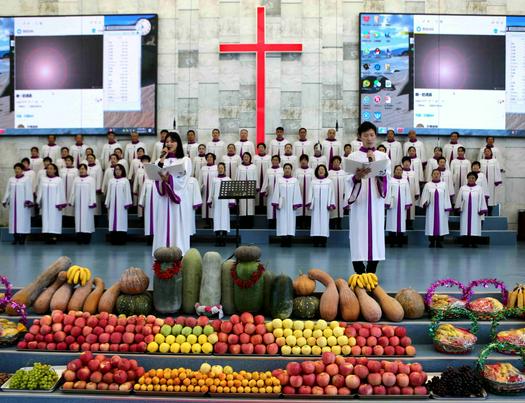 A choir presented a hymn to celebrate the fall harvest with food spread over the floor before the altar in Eternal Life Church, Gaizhou, Liaoning, on October 12, 2021.