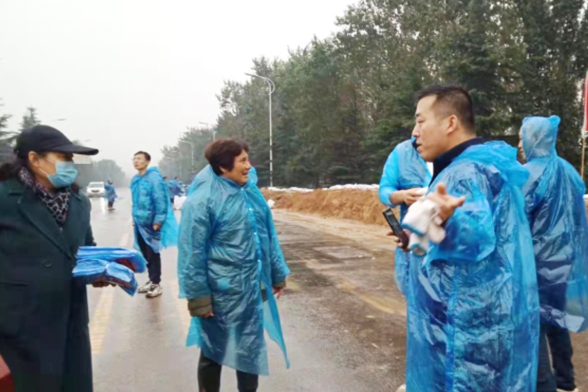 A female believer from a Hejin church in Shanxi distributed raincoats and gloves to volunteers who helped to fight against flood during early mid October, 2021.