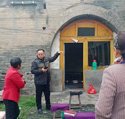 Rev. Fan of Jiexiu Church talked with a believer before the Shitunnan Village meeting point in Jiexiu, Shanxi, which suffered water leakage and cracks on the wall, during a visit on October 14, 2021.