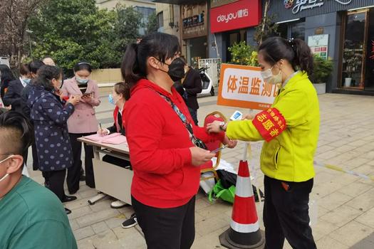 A volunteer of Chengbei Church checked a female's temperature in a testing site of Xiangya Road, Kaifu District, Changsha City, Hunan Province, on October 28, 2021.