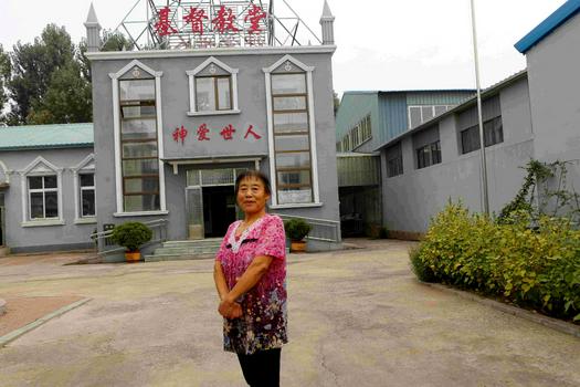 A female believer named Jie Yingmei is pictured in front of a church.