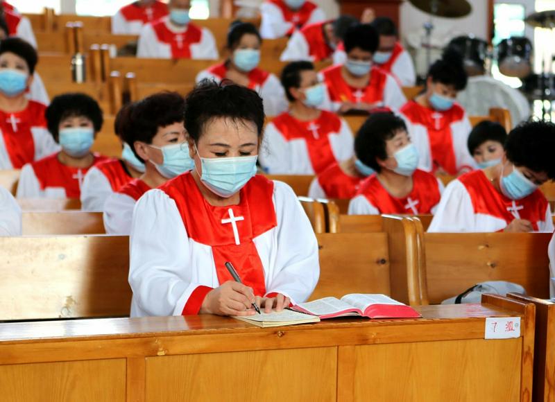A member of the choir of Shuishiying Church in Dalian, Liaoning, took notes while listening to a sermon in a Christmas Sunday service held on December 26, 2021.