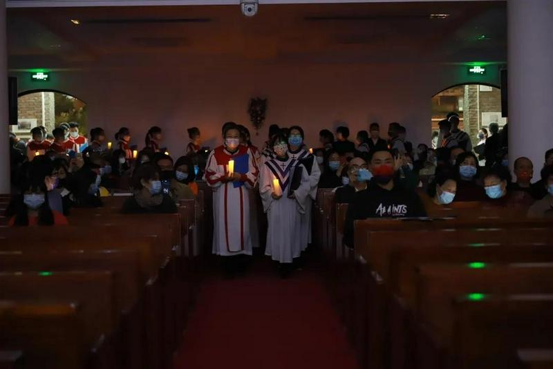 Members of the choir of Guangxiao Church in Guangzhou, Guangdong, entered the sanctuary with candles in their hands to worship God on December 24, 2021.