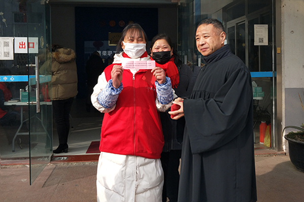 Elder Liu of Xuguan Church in Suzhou, Jiangsu, distributed homemade red envelopes with a paper on which a Bible verse was written after Sunday service on February 6, 2022.