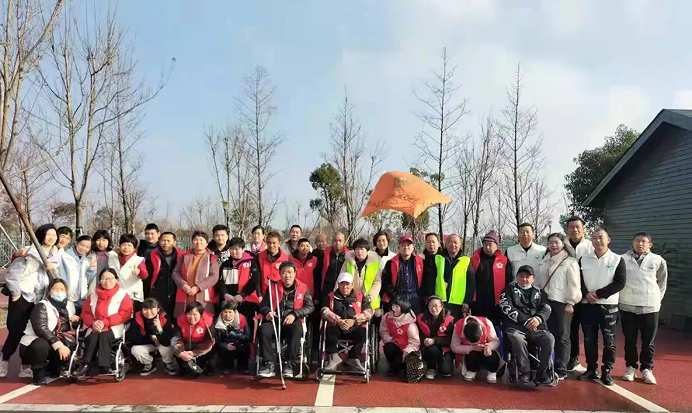 Volunteers of Taizhou Municipal Charity Association in Zhejiang and some disabled people in Zhang'an Street, Jiaojiang District, took a group picture in Taizhou Bay Wetland Park on February 14, 2022.