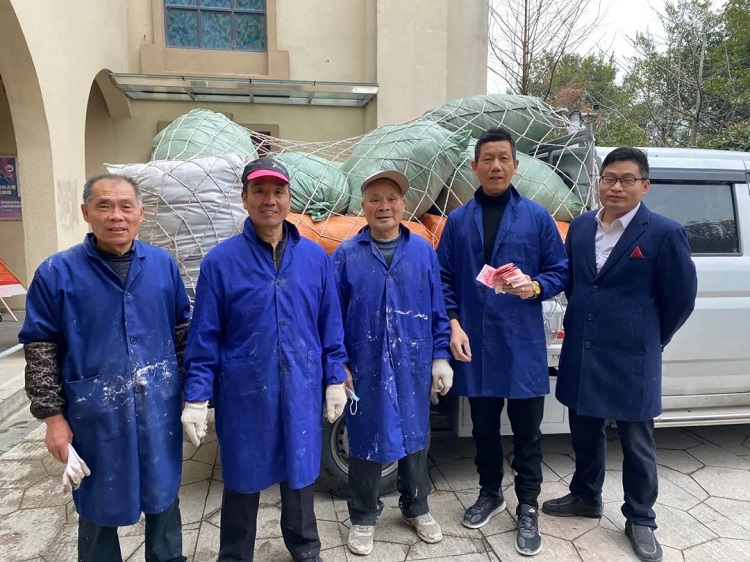 A leader and believers of Jiaojiang Church in Taizhou, Zhejiang, took a group picture after carrying 20 bags of packed clothes to an open truck on March 2, 2022.