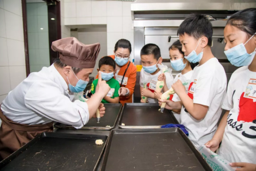 An Amity Bakery worker with intellectual disablity in Nanjing, Jiangsu,  taught children how to make cookie in 2019.