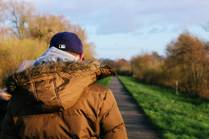 A man with his head down was on a road.