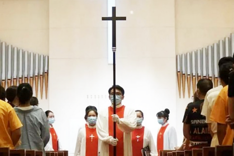 A male church staff held a cross in the159th anniversary commemoration service of Guangzhou Shifu Church in Guangdong on September 19, 2021.