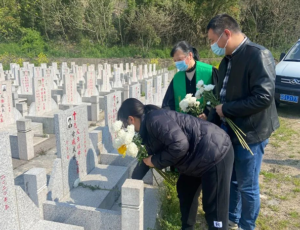 Staff members of Changzhou Church presented flowers to the tombs of deceased believers in a church cemetery in Jiaoxi Town, Changzhou, Jiangsu, on April 1, 2022.