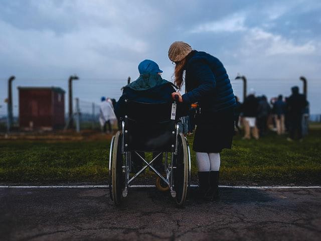 A picture shows a woman accompanying a person in a wheelchair.
