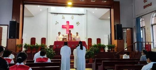 Rev. Qiu Cheng made a holy communion prayer during a Sunday service in Jinsha Church, Nantong, Jiangsu, on June 5, 2022.