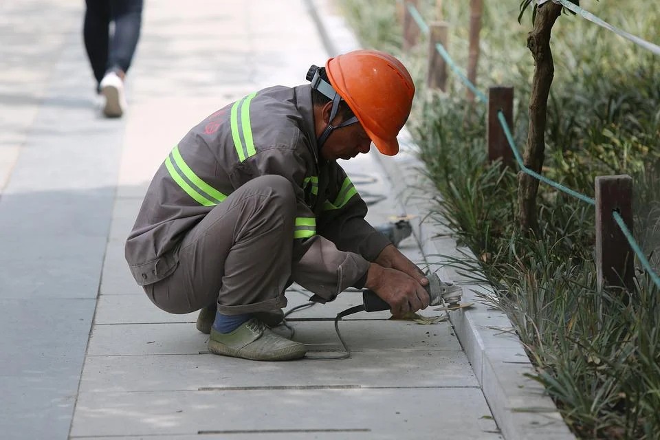 A migrant worker is working on the street. 