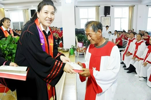 A female pastor presented a baptism certificate and the Bible to a newly baptized member in Chengcheng County Church in Weinan, Shaanxi on July 29, 2022. 