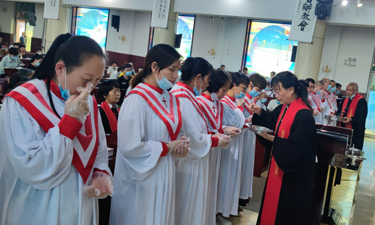 Elder Chen Li distributed the bread to the choir during a baptism service in Yaodu District Church, Linfen, Shanxi, which just reopened on August 7, 2022.