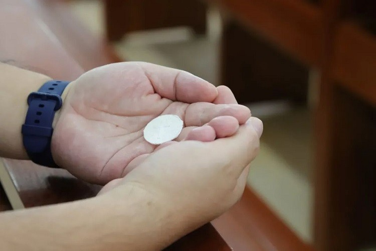 A believer held the bread during a baptism service hosted in Guangxiao Church, Guangzhou, Guangdong, on August 7, 2022.