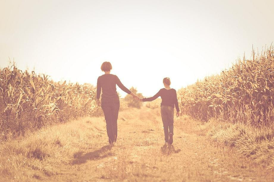 A picture shows a mother and daughter walking hand in hand in the cornfield at an unknow date.