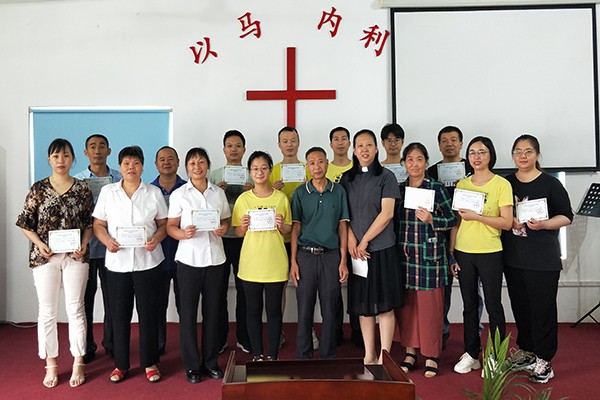 Volunteers of Xu Shu Guan Church in Suzhou, Jiangsu, took a group picture holding graduation certificates of training class on August 28, 2022.
