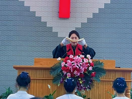Rev. Ge'nan broke the bread during a baptism and communion service in Changtu Church, Tieling, Liaoning, on August 28, 2022.