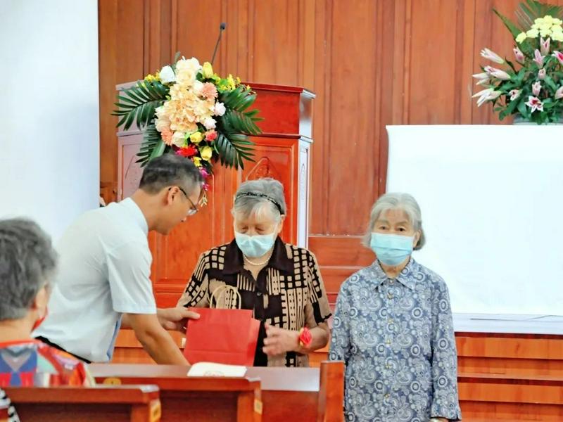 Senior Pastor Zhang Chengtao of Guangxiao Church in Guangzhou, Guangdong, presented a gift  to a female aged believer during a Sunday service on September 11, 2022.