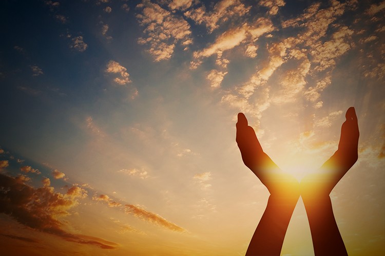 A picture shows hands holding the sun.