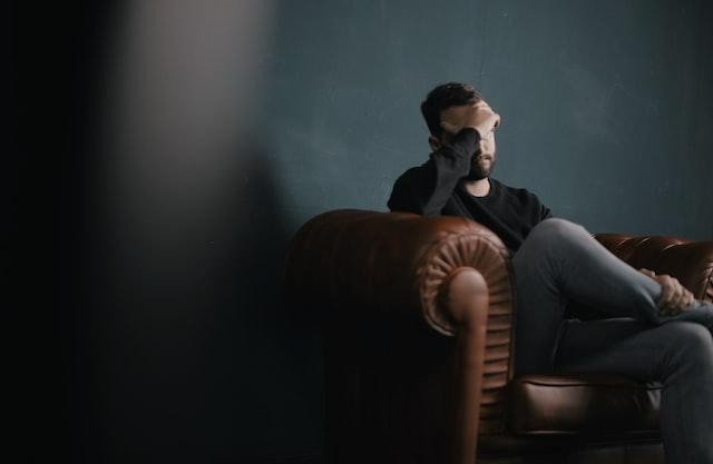 A pictures show a man sitting on the couch with depression.