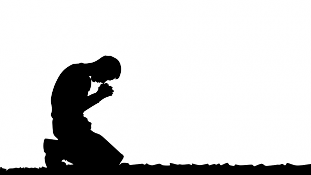 A picture shows a men kneeling in prayer.