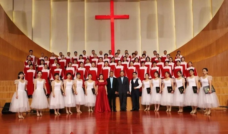 The choir of New Grace Church in Yiwu, Zhejiang, took a group picture with two pastors after they presented programs during the first exchange meeting of church choirs on Sinicization of Christianity in Jinhua City, Zhejiang, on November 12, 2022.