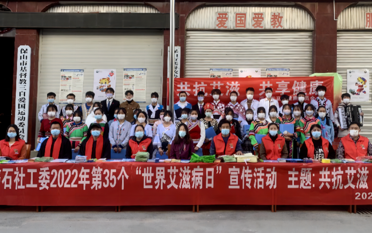 Staff members and participants of a promotional activity took a group picture in front of the station of Baoshan Municipal TSPM on Wrold AIDS Day, December 1, 2022.