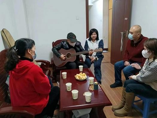 A male believer named Liu Weichang played a guitar just after he received it from members of Gospel Church in Yong'an, Fujian, during a visit on December 10, 2022.