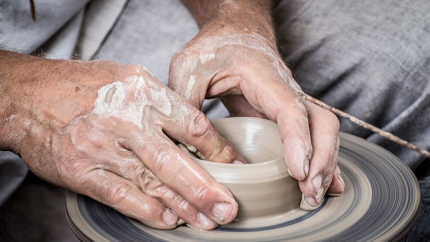A picture show a man making a clay pot.