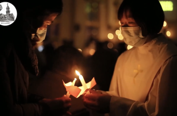 A female believer lit a candle from a staff member during a Christmas Eve candlelight worship service held in the Church of Heavenly Peace in Fuzhou, Fujian, on December 24, 2022.