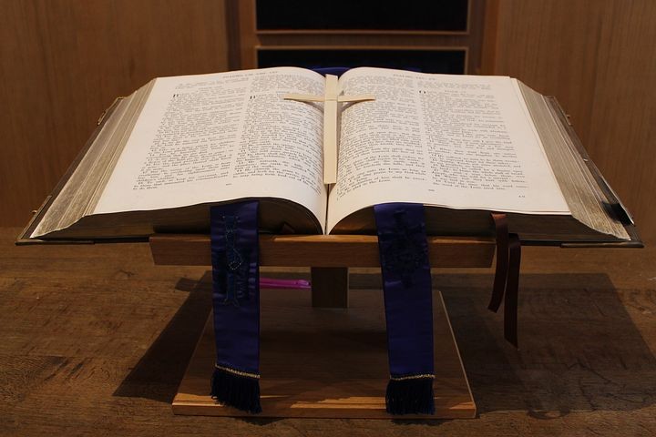 A picture of a large Bible on the table with a cross