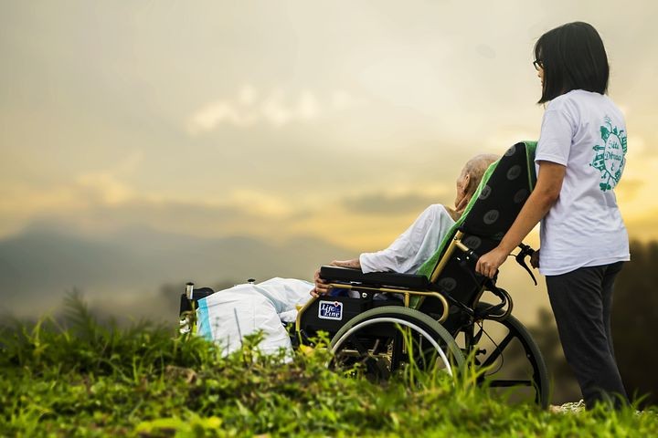 A picture shows a young girl with an old man in a wheelchair.
