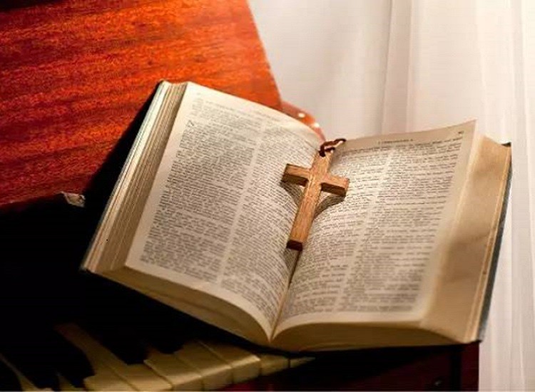 A Bible with a cross on a piano
